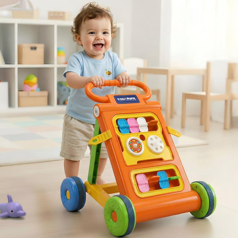 A cheerful toddler stands beside a colorful baby activity walker featuring a toy bar with various interactive elements. The walker is bright orange with green wheels, set in a playful room.