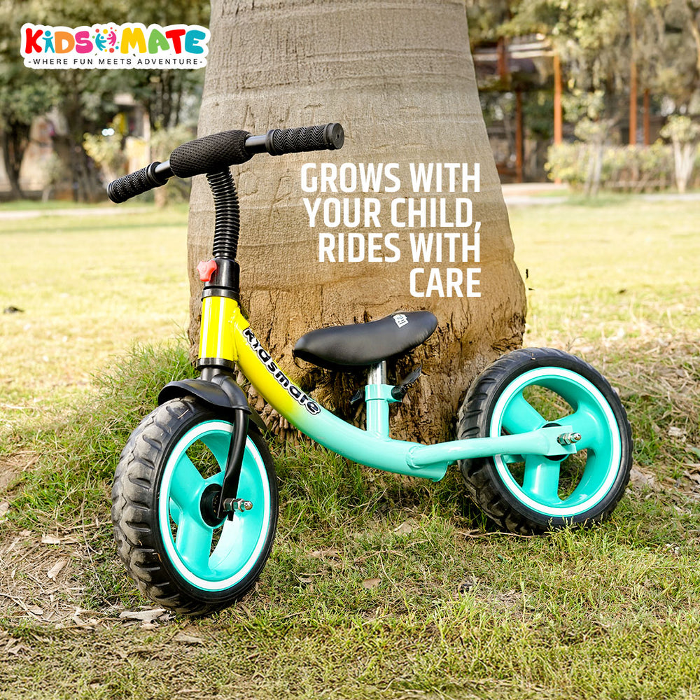 A vibrant turquoise balance bike designed for kids, featuring sturdy rubber tires and a comfortable seat. The bike is set in a sunny outdoor park, surrounded by greenery.