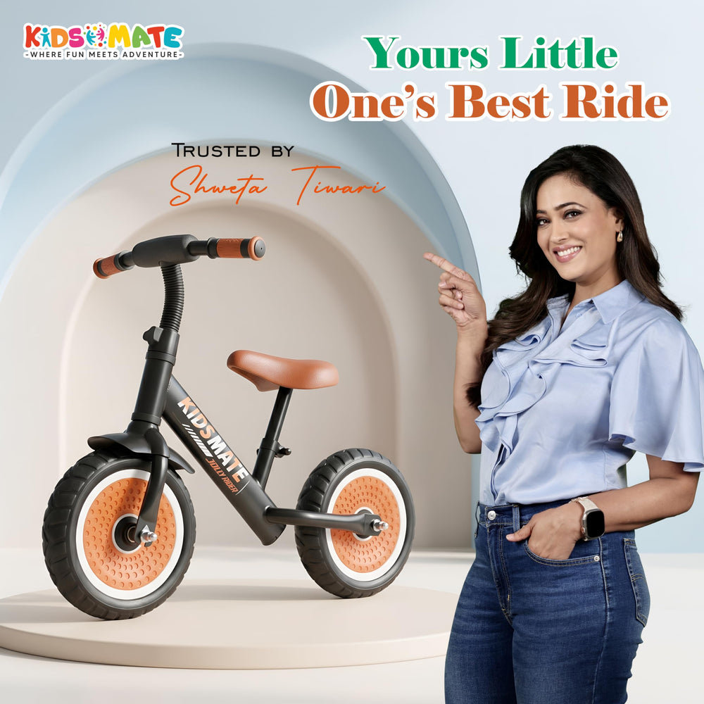 A stylish Jolly Rider Kids Balance Bike with a sleek design, featuring large wheels and a comfortable seat. A smiling woman in a blue blouse stands beside the bike, promoting it as a fun ride for children.