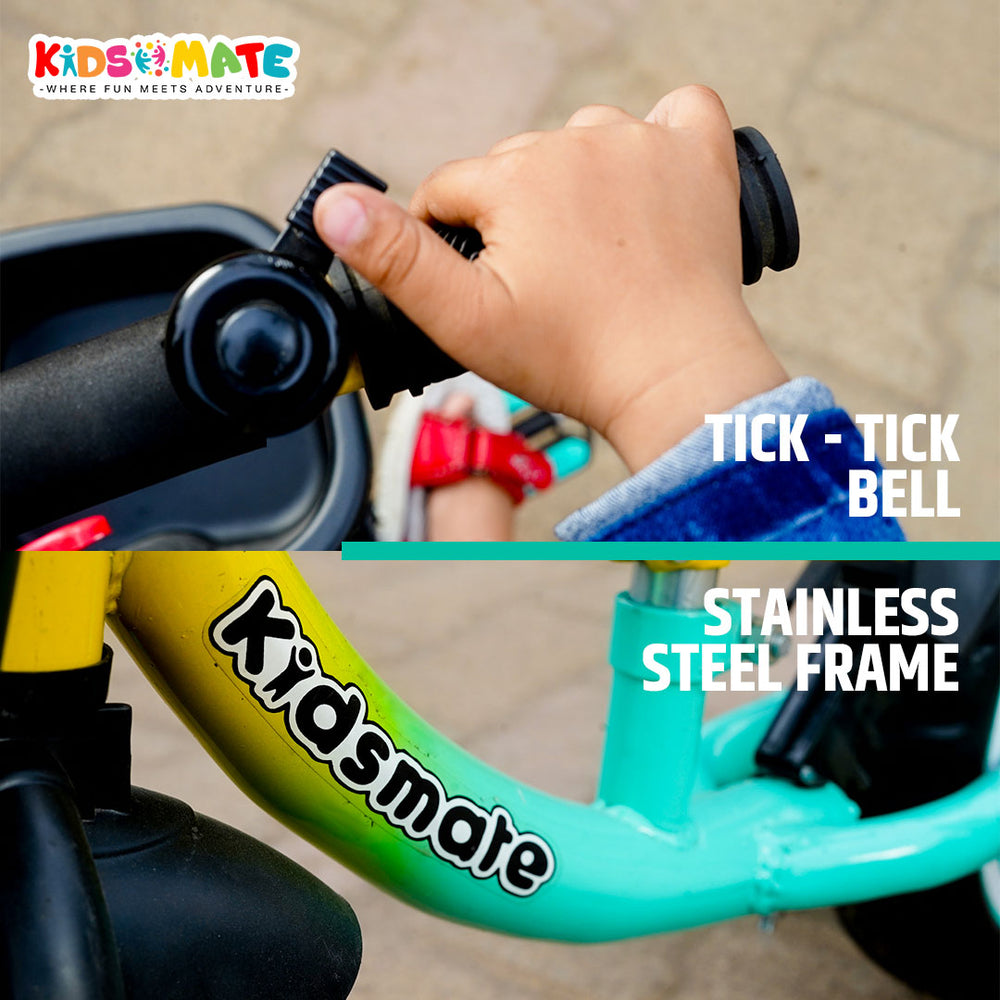 A child's hand gripping the handlebar of a balance cycle, showcasing a bell and a colorful frame with a visible 'Kidsmate' logo. The cycle is designed for fun and adventure.