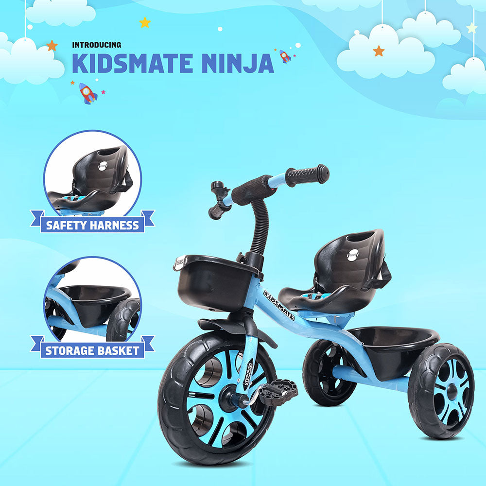 A vibrant blue tricycle designed for kids, featuring a safety harness and a storage basket. The background is bright with clouds and rockets, creating a playful atmosphere.