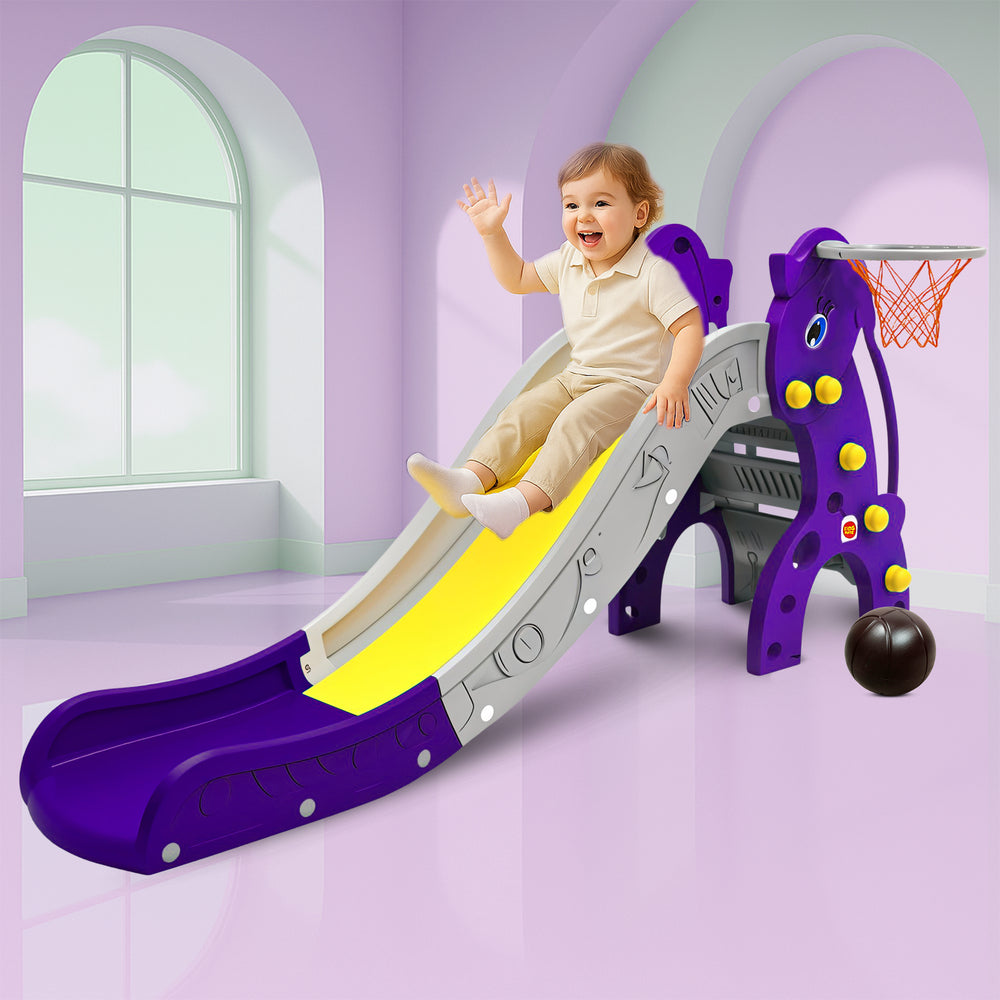 A cheerful child slides down a vibrant purple and yellow slide, featuring a basketball hoop and playful design, set against a light purple room with large windows.