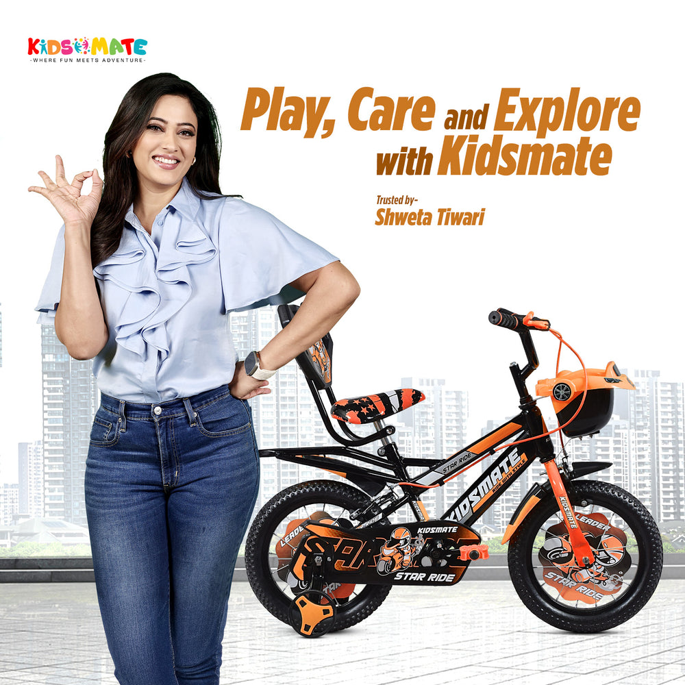 A vibrant kids bicycle with training wheels, featuring a black and orange design. A smiling woman in a stylish outfit poses beside the bike, promoting play and exploration.